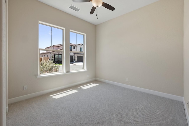 carpeted empty room with a ceiling fan and baseboards