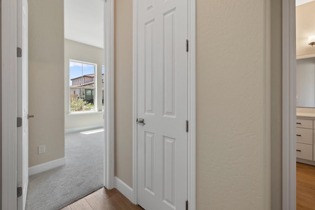 hallway with dark wood finished floors and baseboards