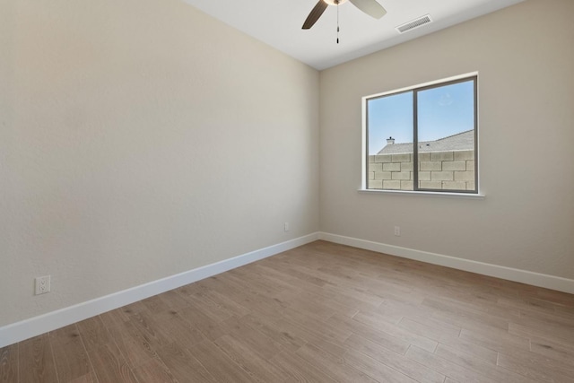 spare room featuring ceiling fan, baseboards, and wood finished floors