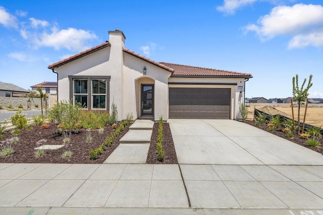 mediterranean / spanish-style house featuring stucco siding, a tile roof, an attached garage, concrete driveway, and a chimney