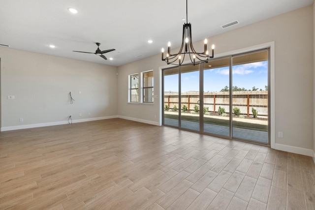 empty room featuring baseboards, light wood finished floors, a chandelier, ceiling fan, and recessed lighting