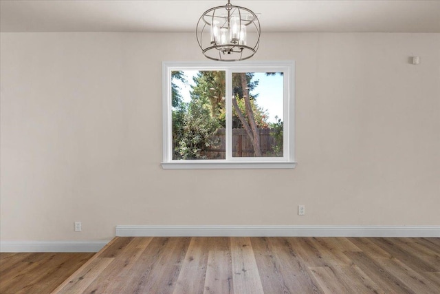 5706 N Tamera Ave, Fresno, CA 93711 - unfurnished dining area with a chandelier, baseboards, and wood finished floors