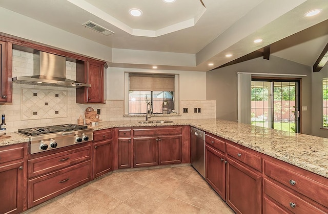 1025 E Cambridge Ave, Visalia, CA 93292 - kitchen featuring stainless steel appliances, wall chimney exhaust hood, a tray ceiling, backsplash, and light stone counters