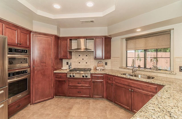 1025 E Cambridge Ave, Visalia, CA 93292 - kitchen featuring wall chimney range hood, stainless steel appliances, a sink, backsplash, and a tray ceiling