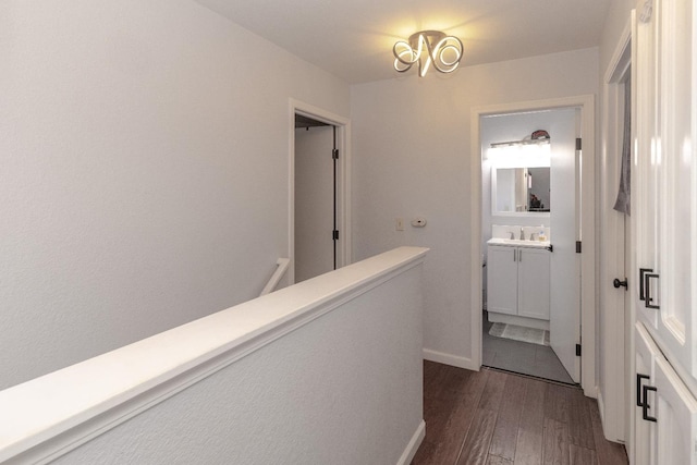 3626 E Stewart Ct, Visalia, CA 93292 - hallway featuring dark wood finished floors, a sink, an upstairs landing, and baseboards