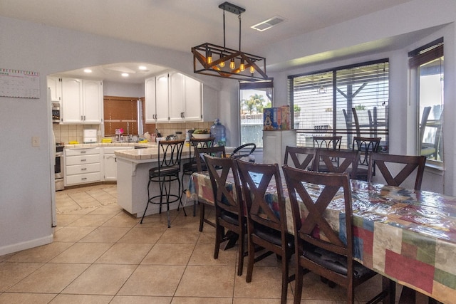 3626 E Stewart Ct, Visalia, CA 93292 - dining room with light tile patterned floors, arched walkways, and recessed lighting