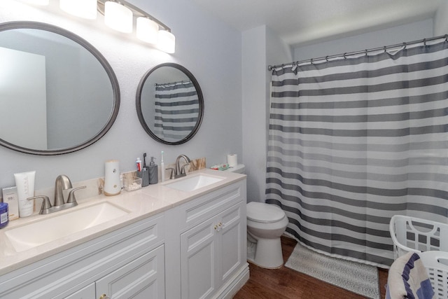 3626 E Stewart Ct, Visalia, CA 93292 - bathroom featuring wood finished floors, double vanity, and toilet