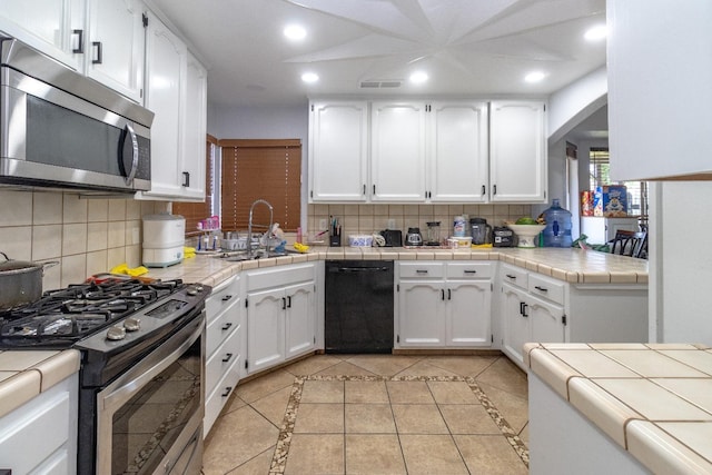 3626 E Stewart Ct, Visalia, CA 93292 - kitchen with appliances with stainless steel finishes, a sink, white cabinets, decorative backsplash, and recessed lighting