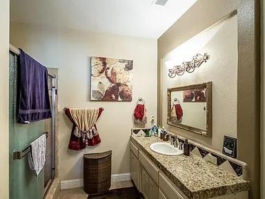 full bathroom featuring vanity, a shower stall, and baseboards