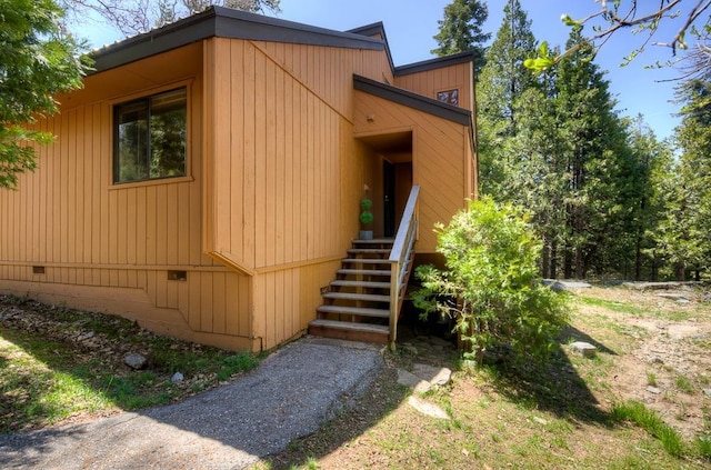view of property exterior with crawl space and stairs