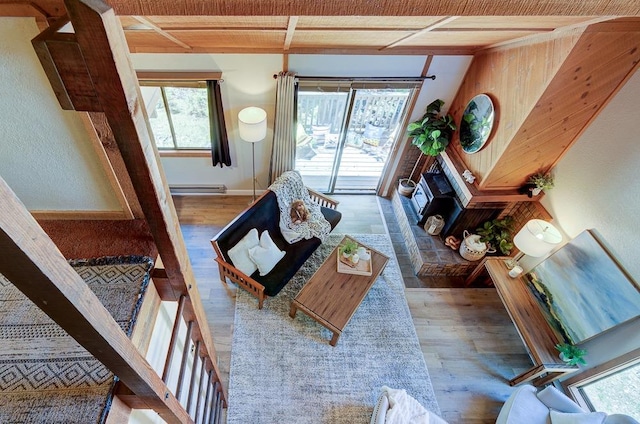 living room with wood finished floors, a baseboard heating unit, and baseboards