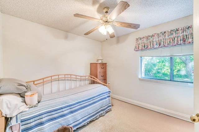 carpeted bedroom featuring a textured ceiling, ceiling fan, and baseboards