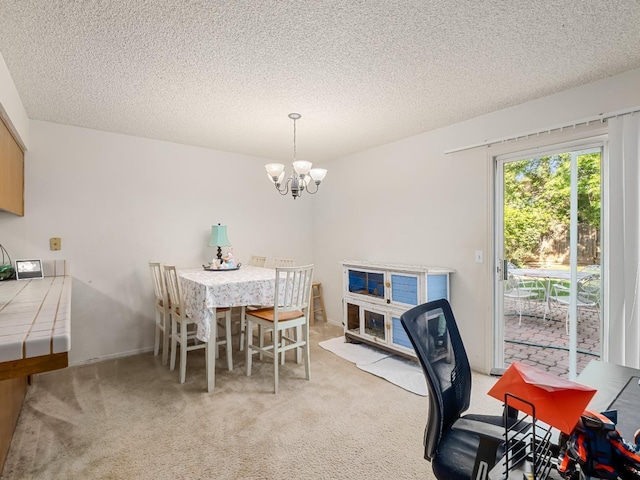 dining space with a chandelier, a textured ceiling, and light colored carpet