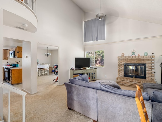living room featuring high vaulted ceiling, light carpet, a chandelier, a brick fireplace, and baseboards