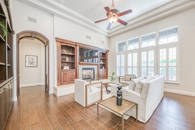 7762 N Hillsdale Dr, Fresno, CA 93720 - living area featuring a towering ceiling, a multi sided fireplace, ceiling fan, baseboards, and wood finished floors