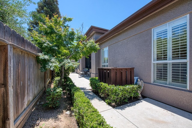 7762 N Hillsdale Dr, Fresno, CA 93720 - view of side of home featuring a patio, stucco siding, and a fenced backyard