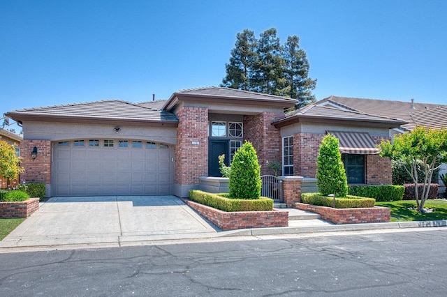 7762 N Hillsdale Dr, Fresno, CA 93720 - view of front of home with brick siding, an attached garage, driveway, and a tiled roof