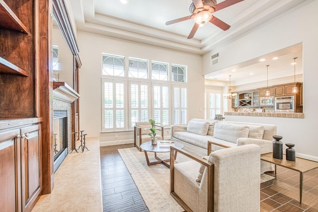 7762 N Hillsdale Dr, Fresno, CA 93720 - living room with baseboards, a fireplace, a ceiling fan, a high ceiling, and a raised ceiling