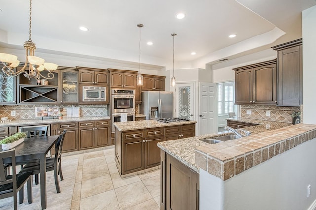 7762 N Hillsdale Dr, Fresno, CA 93720 - kitchen with stainless steel appliances, a sink, backsplash, a center island, and a chandelier