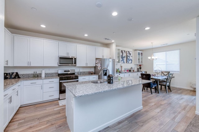 359 Rebel St, Reedley, CA 93654 - kitchen with appliances with stainless steel finishes, a chandelier, light wood-type flooring, an island with sink, and white cabinetry
