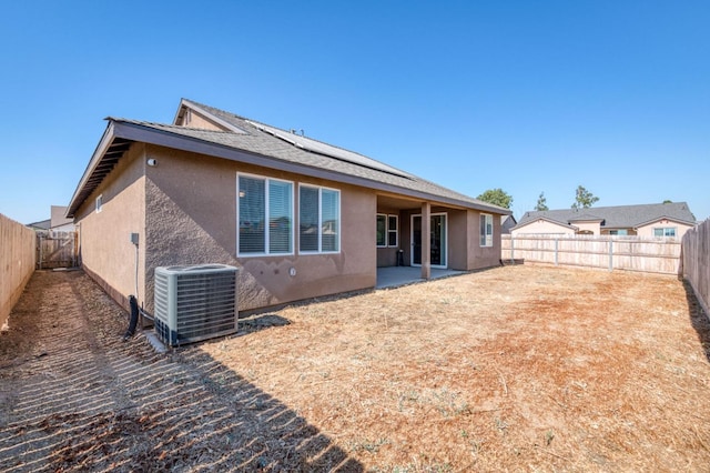 359 Rebel St, Reedley, CA 93654 - back of house featuring central AC, stucco siding, a fenced backyard, and a patio