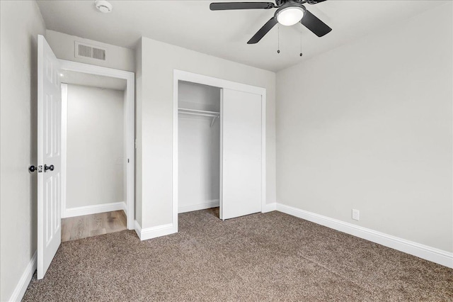 unfurnished bedroom featuring carpet flooring, a closet, baseboards, and a ceiling fan