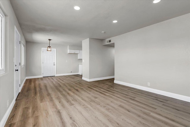 spare room featuring wood finished floors, baseboards, and recessed lighting