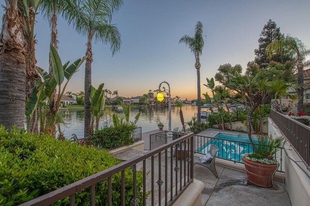2589 W Lake Van Ness Cir, Fresno, CA 93711 - balcony at dusk featuring a water view and view of pool area