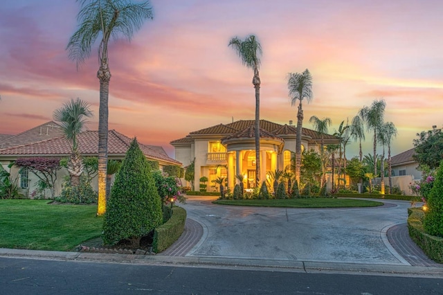 2589 W Lake Van Ness Cir, Fresno, CA 93711 - mediterranean / spanish-style home featuring curved driveway, a lawn, stucco siding, and a tile roof