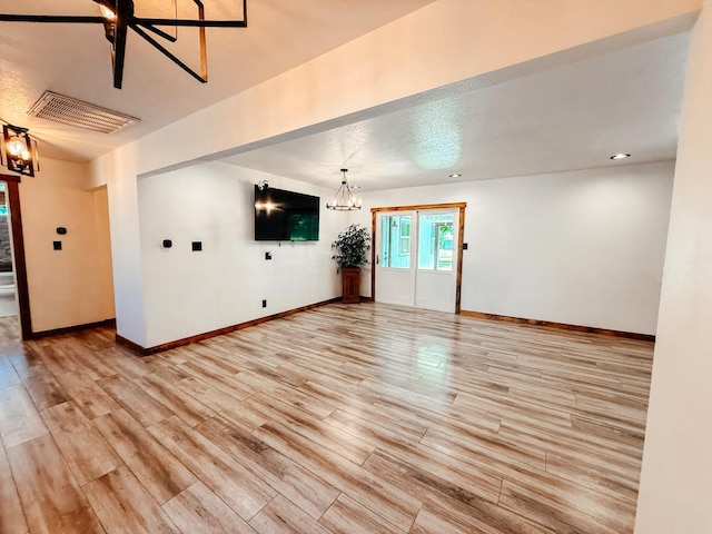 7784 S Del Rey Ave, Del Rey, CA 93616 - unfurnished living room featuring a chandelier, light wood-type flooring, and baseboards