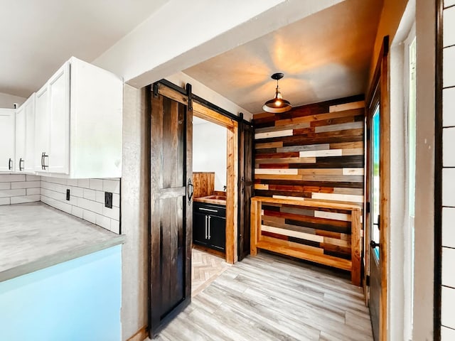 7784 S Del Rey Ave, Del Rey, CA 93616 - hallway with a barn door, light wood-style flooring, and wood walls