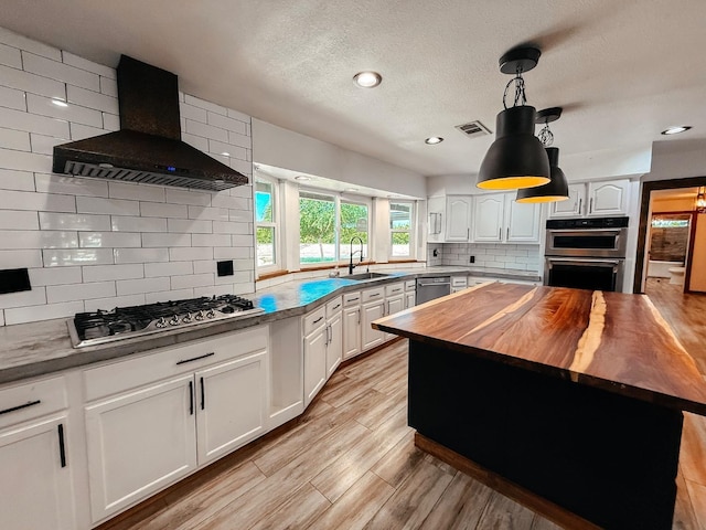 7784 S Del Rey Ave, Del Rey, CA 93616 - kitchen featuring wooden counters, wall chimney exhaust hood, stainless steel appliances, a sink, and tasteful backsplash