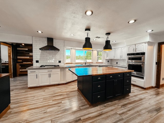 7784 S Del Rey Ave, Del Rey, CA 93616 - kitchen with wooden counters, wall chimney exhaust hood, dark cabinets, white cabinets, and stainless steel appliances