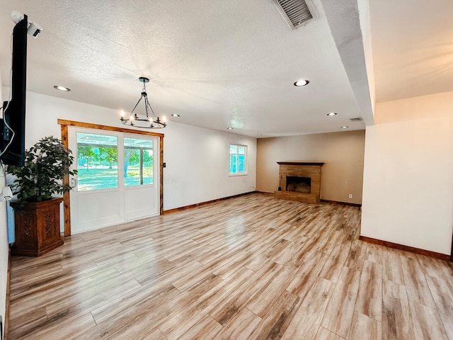 7784 S Del Rey Ave, Del Rey, CA 93616 - unfurnished living room with light wood-type flooring, a chandelier, recessed lighting, baseboards, and a textured ceiling