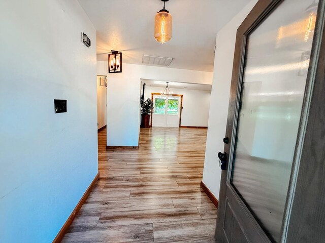 7784 S Del Rey Ave, Del Rey, CA 93616 - hallway featuring baseboards, a chandelier, and wood finished floors