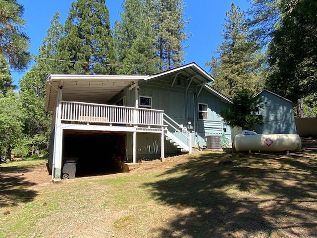 50740 Chu Ranch Rd, Oakhurst, CA 93644 - rear view of property with stairway, a wooden deck, central AC unit, board and batten siding, and a yard