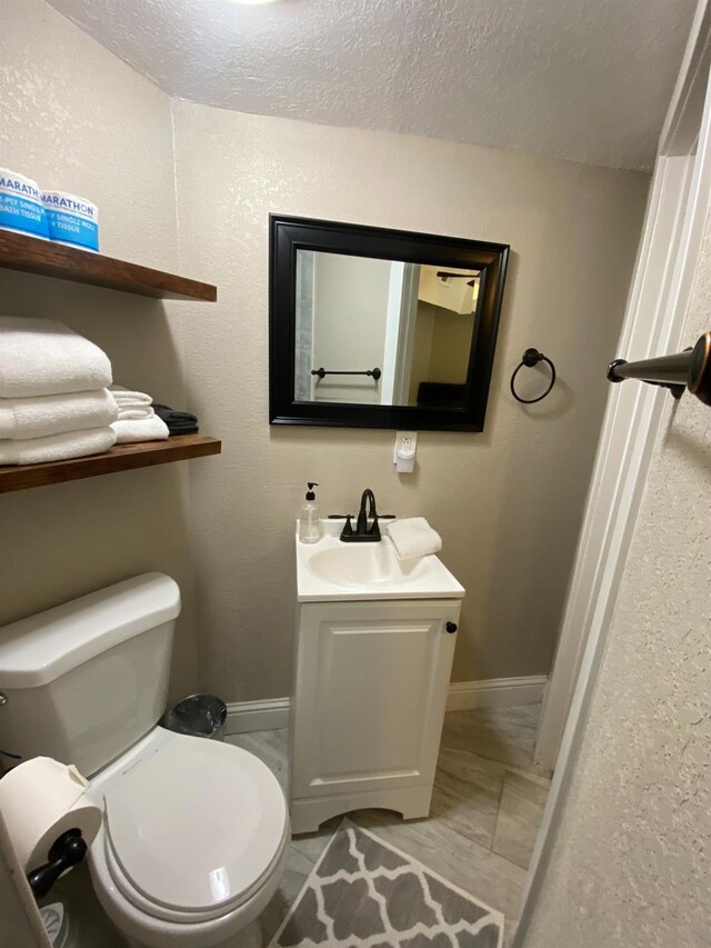 50740 Chu Ranch Rd, Oakhurst, CA 93644 - bathroom featuring baseboards, toilet, a textured ceiling, and vanity