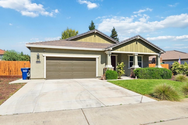 2315 Creekview Dr, Merced, CA 95340 - craftsman-style home with an attached garage, concrete driveway, a porch, a tile roof, and stucco siding