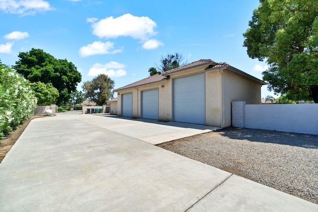 3365 N Emperor Ave, Fresno, CA 93737 - view of side of home with stucco siding, fence, a detached garage, and a tiled roof