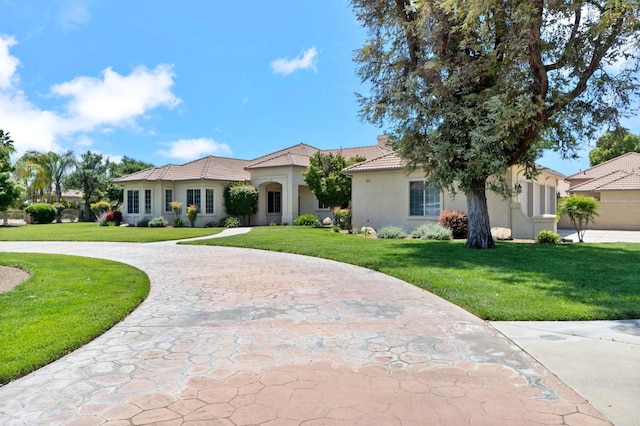 3365 N Emperor Ave, Fresno, CA 93737 - mediterranean / spanish house featuring curved driveway, stucco siding, a front yard, and a tile roof
