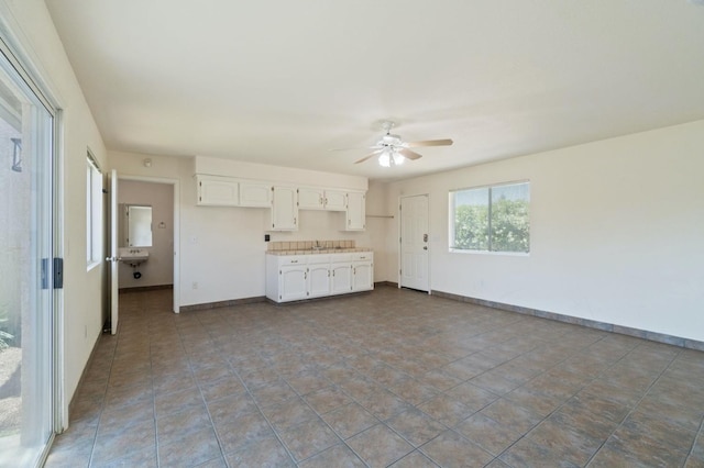 3365 N Emperor Ave, Fresno, CA 93737 - unfurnished living room with a ceiling fan, baseboards, and a sink