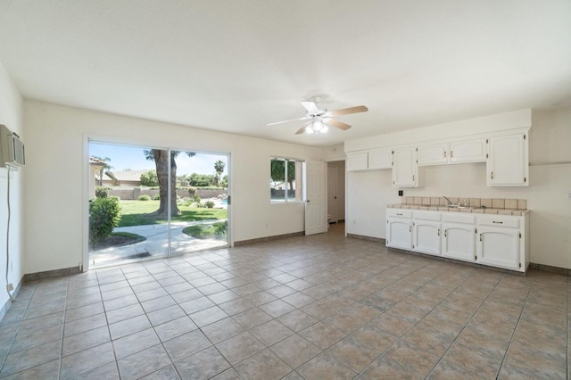 3365 N Emperor Ave, Fresno, CA 93737 - kitchen with ceiling fan, baseboards, white cabinetry, and light tile patterned flooring