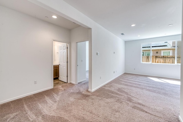 spare room featuring light colored carpet, baseboards, and recessed lighting