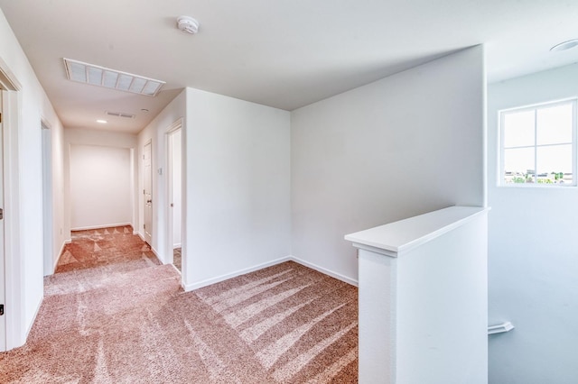 hallway with carpet floors, an upstairs landing, and baseboards