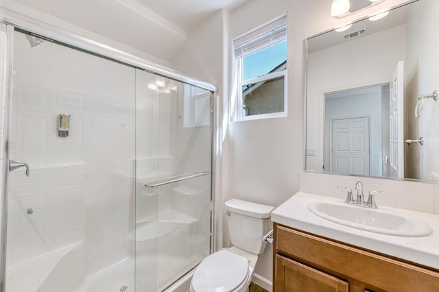 bathroom featuring toilet, a stall shower, and vanity