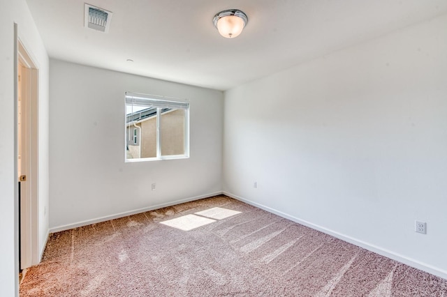 carpeted empty room featuring baseboards