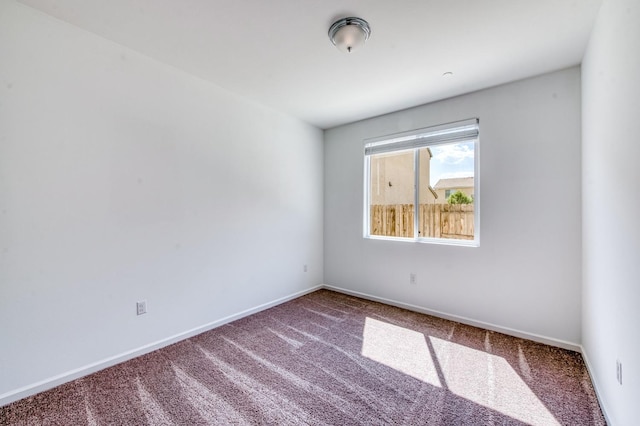 carpeted spare room featuring baseboards