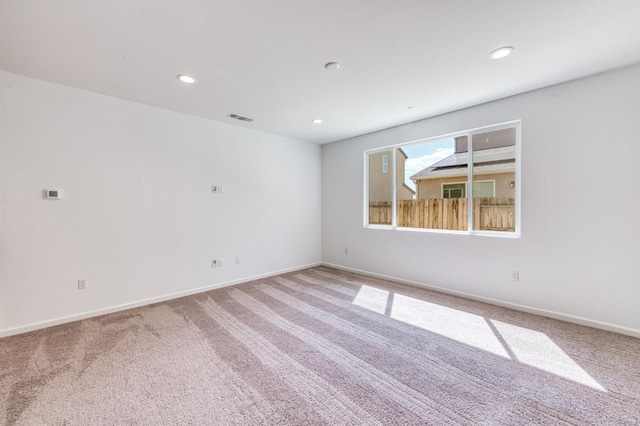 empty room with carpet floors, recessed lighting, and baseboards