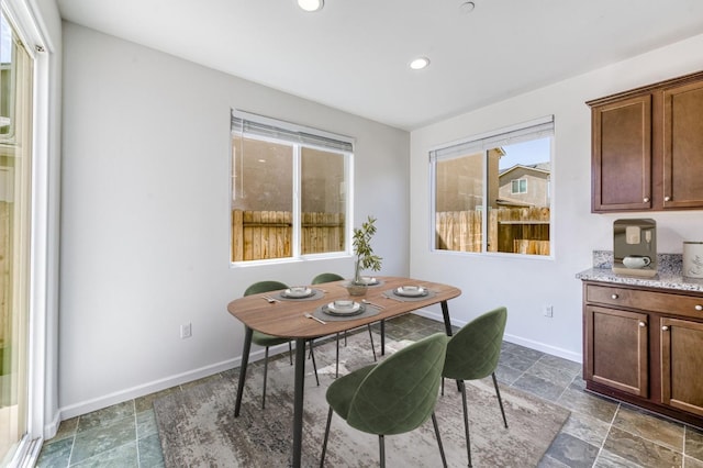 dining area with baseboards, recessed lighting, and stone finish flooring