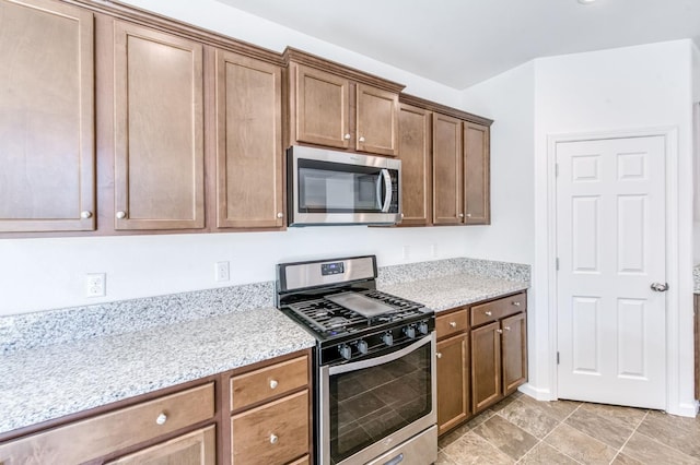 kitchen featuring stainless steel appliances and light stone counters